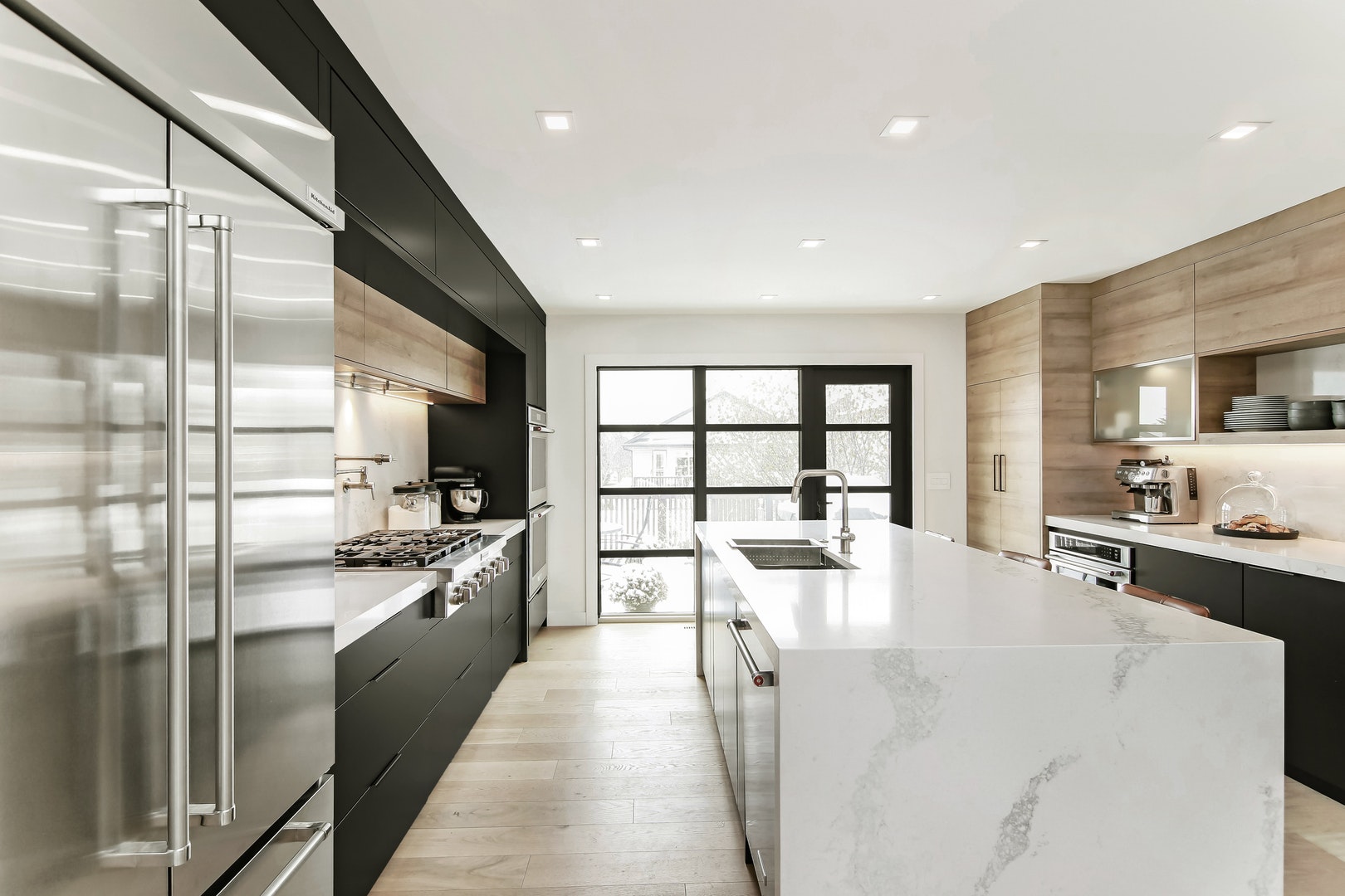 Kitchen renovation with white island and dark cabinets in "Modern Makeover" by RenoMark Member Reborn Renovations, Finalist in the 2021 CHBA National Awards for Housing Excellence.